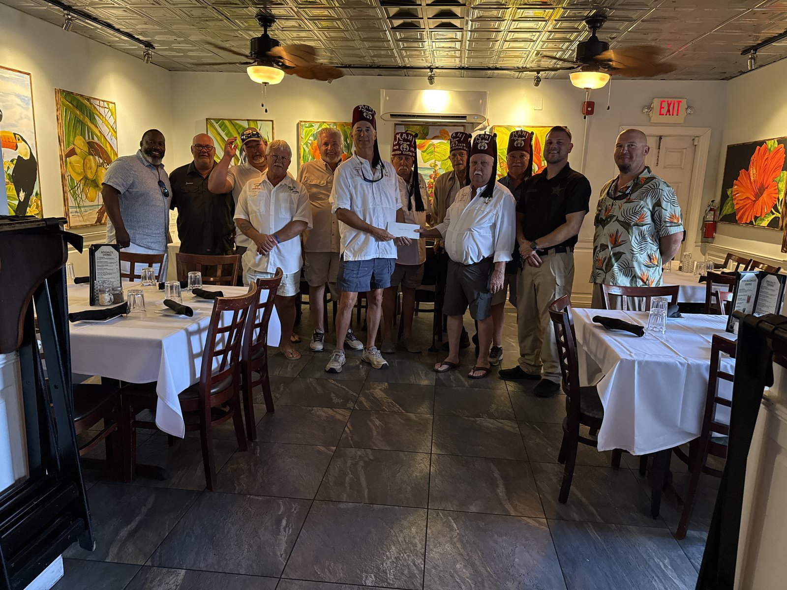 Members of the Marathon Shrine Club holding a presentation check inside the Florida Steak and Lobster House.