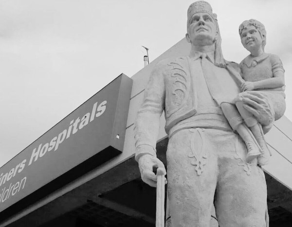 Statue of a Shriner carrying a child, outside Shriners Hospitals for Children.